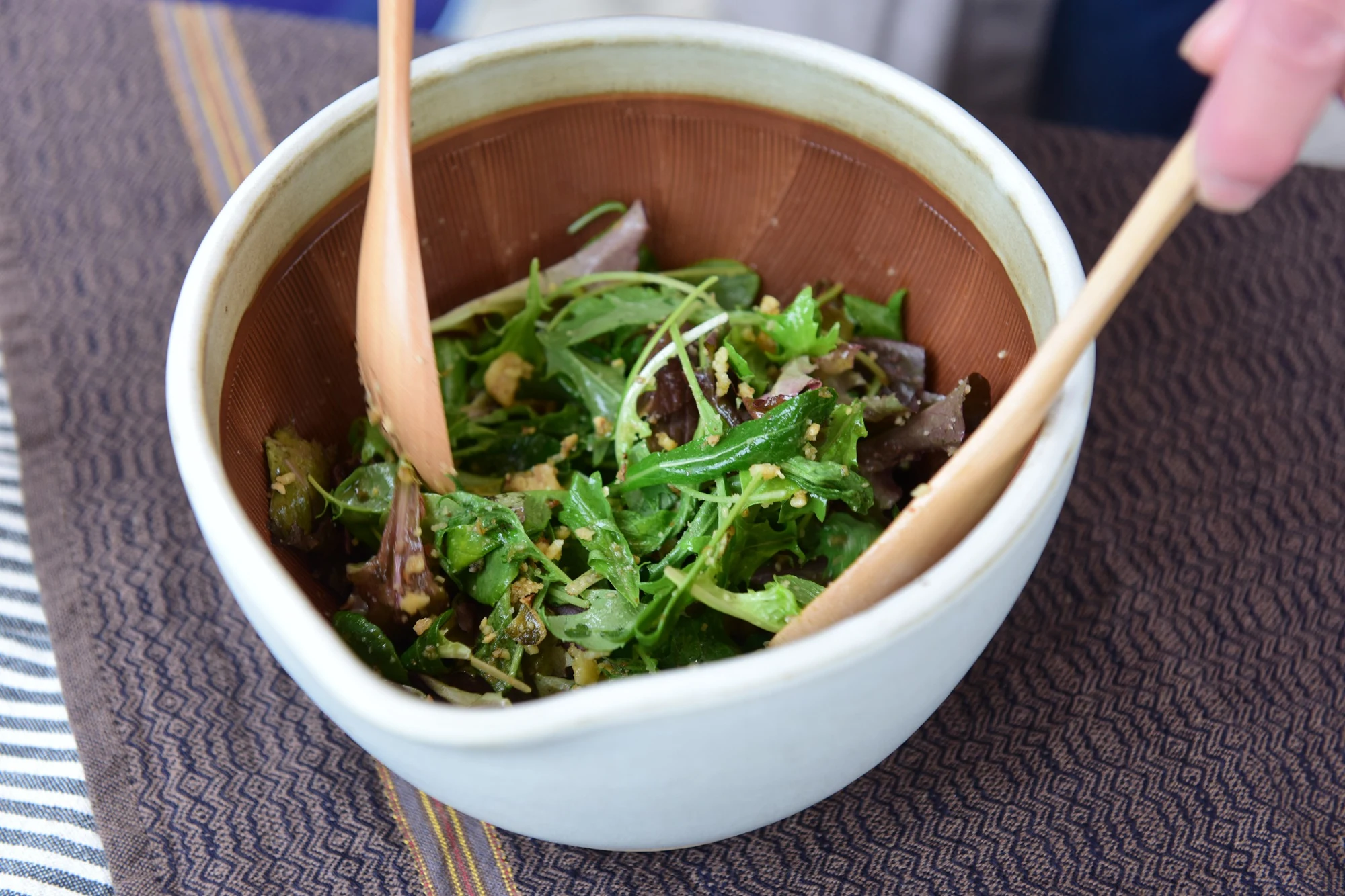 白いすり鉢で和えた野菜を食卓へ